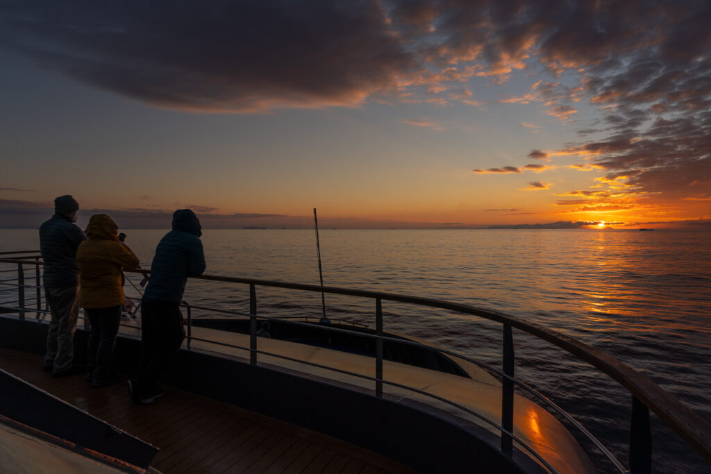 Guests watching the polar sunset from the expedition ship