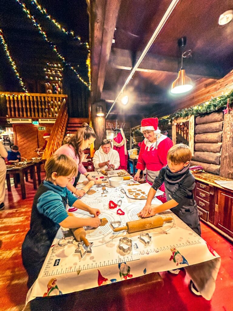 Niños y adultos decorando pan de jengibre en un taller navideño