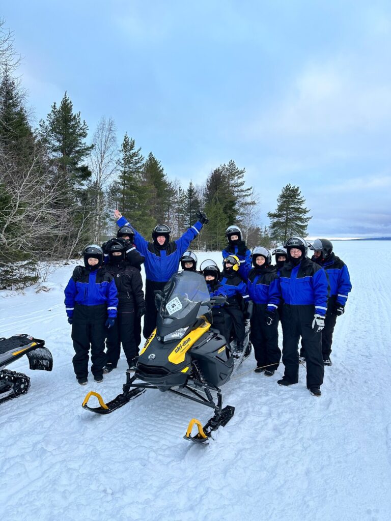 Viajeros de IBG Travel preparados para una excursión guiada en moto de nieve en Vuokatti