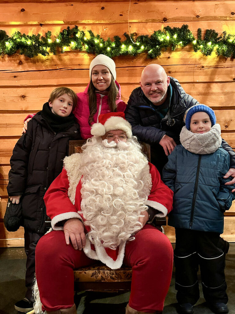 Family meeting Santa Claus during the New Year programme in Vuokatti
