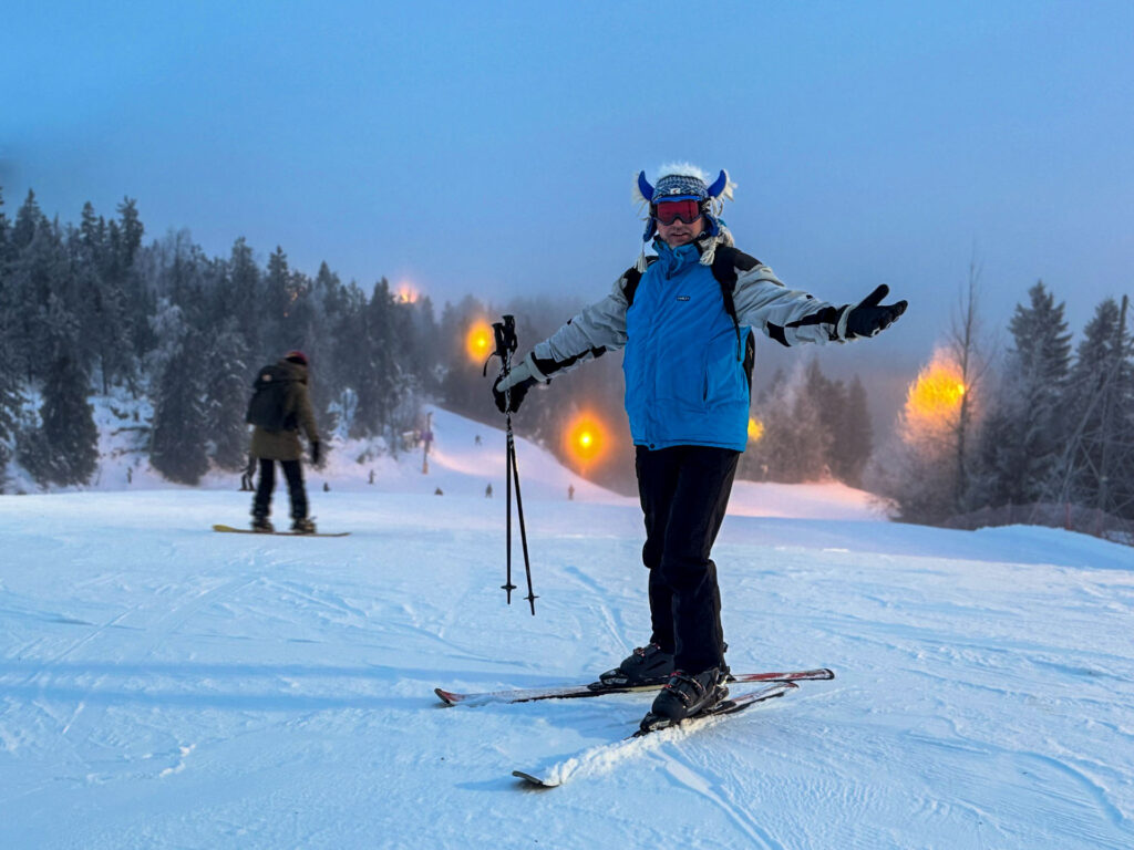 Viajero esquiando en una pista nevada de Vuokatti al atardecer